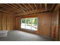 Framed interior view with large windows showing the building process of the new home at 214 Wild Ginger Bnd, Woodstock, GA 30188