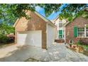 Charming brick home with a two-car garage, green door and shutters and a landscaped yard at 1740 Ambercrest Pl, Buford, GA 30518