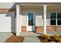 Inviting front porch with brick accents and modern lighting, leading to the home's entrance at 205 Carrington Pt, Canton, GA 30115