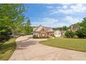 Inviting front exterior featuring a brick and siding facade, long driveway and well-manicured lawn and landscaping at 2191 Lakeview Pkwy, Villa Rica, GA 30180
