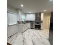 Modern kitchen with white cabinets, stainless steel appliances, and marble floors at 2833 Oldknow Nw Dr, Atlanta, GA 30318