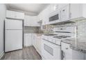 Well-lit kitchen with white appliances, granite countertops, and tiled backsplash at 620 Peachtree Ne St # 601, Atlanta, GA 30308