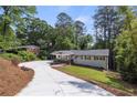 Beautifully renovated home with a long driveway, lush landscaping, and a charming front porch and carport at 6835 Sunny Brook Ln, Atlanta, GA 30328