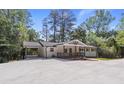 Inviting renovated home featuring a covered carport, and a lovely front porch, surrounded by mature trees at 6835 Sunny Brook Ln, Atlanta, GA 30328
