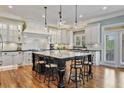 Spacious kitchen featuring a large island with bar seating, custom cabinets, and pendant lighting at 3920 Ineal Dr, Cumming, GA 30028