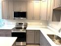 Modern kitchen featuring stainless steel appliances, gray cabinetry, and stone countertops at 5091 Newark Ave, Clarkdale, GA 30111