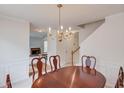 Well-lit dining area featuring crown molding, with staircase and glimpse into the living room at 512 Antler Ln, Suwanee, GA 30024