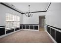 Bright and airy living room featuring neutral carpet, black accents and classic chandelier at 5244 Carrington Park Dr, Powder Springs, GA 30127