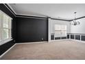 Spacious carpeted living room with black accent paint and a classic chandelier at 5244 Carrington Park Dr, Powder Springs, GA 30127