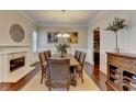 Open dining room featuring a fireplace, wood floors, large table, and crown molding at 4892 Kentwood Dr, Marietta, GA 30068