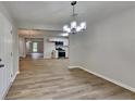 A dining area with modern light fixture adjacent to an open kitchen with stainless appliances at 5326 Nader Pl, Stone Mountain, GA 30088