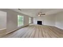 Spacious living room featuring new flooring, a fireplace, and natural light through large windows at 5326 Nader Pl, Stone Mountain, GA 30088