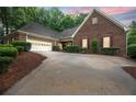 Beautiful brick home with a spacious driveway, two-car garage, and well-manicured landscaping at 9395 Clublands Dr, Alpharetta, GA 30022