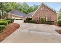 Classic brick home with a two-car garage, long driveway, and lush greenery, exuding curb appeal at 9395 Clublands Dr, Alpharetta, GA 30022