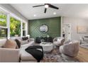 Stylish living room with decorative green accent wall, plush seating, and large windows offering natural light at 2026 Rebecca Ln, Decatur, GA 30032