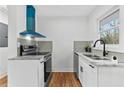 Modern kitchen featuring a stainless steel oven and range with a stylish blue vent at 2211 Macon Sw Dr, Atlanta, GA 30315