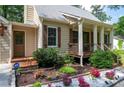 Inviting front porch with wood railing and columns, plus colorful flower beds at 3078 Alberta Dr, Marietta, GA 30062
