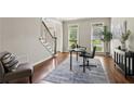 Home office featuring hardwood floors, natural light, and a workspace with a desk, chair, and area rug at 4140 Lansfaire Ter, Suwanee, GA 30024