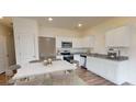 Open kitchen with stainless steel appliances and marble counters, perfect for entertaining at 410 Chaleur Way, Locust Grove, GA 30248