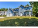 Charming two-story home featuring a two-car garage and beautiful blue siding at 6220 Polar Fox Ct, Riverdale, GA 30296