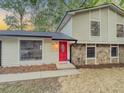 Charming two-story home with a well-maintained lawn, stone accents and bright red front door at 8007 Northcrest Dr, Jonesboro, GA 30238