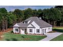 Well-manicured lawn surrounds a modern farmhouse-style home with an attached two-car garage at 140 Paislee Park (Lot #5 Paislee Park) Dr, Fayetteville, GA 30215