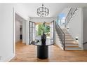 Grand foyer featuring hardwood floors, elegant lighting, and a staircase with a black metal banister at 3267 Sewell Mill Rd, Marietta, GA 30062