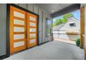 Inviting front porch featuring a modern wood-frame glass door and gray painted wood paneled siding at 34 Candler Ne Rd, Atlanta, GA 30317