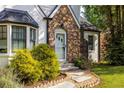 Close-up of the home's stone accent, white door with sidelights, and bay window, creating a warm and inviting entrance at 1334 Milton Se Pl, Atlanta, GA 30316