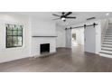 Bright living room with wood floors, a painted brick fireplace, and sliding barn doors creating an open layout at 1334 Milton Se Pl, Atlanta, GA 30316