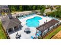 Aerial view of a community pool area with lounge chairs and landscaped surroundings at 3167 Moor View Rd # 35, Duluth, GA 30096