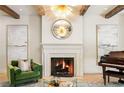 Bright living room featuring fireplace, piano, artwork, and modern lighting fixture at 5205 Riverview Nw Rd, Atlanta, GA 30327