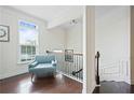 Sunlit upper hallway with stylish chair and wrought iron railing at 6294 Century Park Se Pl, Mableton, GA 30126