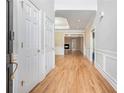 Inviting hallway featuring gleaming hardwood floors, elegant moldings, and seamless flow into the living spaces at 2050 Woodberry Run Dr, Snellville, GA 30078