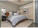 Comfortable bedroom features modern decor, exposed concrete wall, neutral colors, and a large window with natural light at 480 John Wesley Dobbs Ne Ave # 418, Atlanta, GA 30312