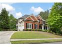 Attractive brick and siding home with a well-kept lawn, black shutters, and an extended driveway at 105 Thorncliff Way, Acworth, GA 30101
