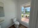 Half-bathroom features a modern toilet and a window overlooking the front yard at 2093 Boxwood Se Cir, Conyers, GA 30094