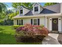 Eye-level of charming house showing a black door with a wreath and landscaping in the front yard at 161 Brookfield Dr, Stockbridge, GA 30281