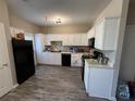 Functional kitchen featuring white cabinetry, black appliances, and vinyl plank flooring at 229 Odyssey Turn, Conyers, GA 30012