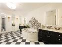 Luxurious bathroom with a soaking tub, marble accents, dual vanities, and black-and-white checkered floors at 3344 Peachtree Ne Rd # 3005, Atlanta, GA 30326