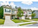 View of well-maintained townhomes featuring neat lawns, driveways, and architectural details on a sunny day at 692 Oakside Pl, Acworth, GA 30102