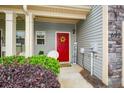Inviting front porch featuring a red door with wreath and colorful landscaping at 692 Oakside Pl, Acworth, GA 30102