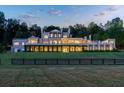 Rear exterior view of the estate featuring a covered veranda, well-maintained lawn, and distant paddock at 1040 W Conway Nw Dr, Atlanta, GA 30327