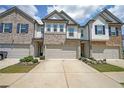 Exterior view of townhouses featuring multi-car driveways, 2-car garages, brick, siding, and small front lawns at 1312 Cooper Springs Rd, Grayson, GA 30017