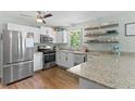 Modern kitchen featuring stainless steel appliances, granite counters, and floating shelves at 3517 Greenway Dr, Marietta, GA 30008