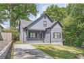 Charming home featuring a quaint front porch and traditional architectural details surrounded by mature trees and manicured lawn at 558 Elbridge Nw Dr, Atlanta, GA 30318