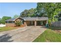 Brick home featuring a connected carport and a long driveway on a sunny day at 6459 Paula Ct, Rex, GA 30273