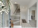 Bright foyer with staircase, light wood floors, and entry to powder room at 1117 Larkin Dr, Buford, GA 30518