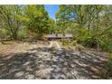 Gravel driveway leading to a log home surrounded by beautiful trees, nature, and privacy at 2377 Pine Mountain Rd, Kennesaw, GA 30152