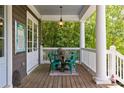 Inviting back porch with outdoor dining set, perfect for enjoying nature views and outdoor living at 10559 Serenbe Ln, Chattahoochee Hills, GA 30268